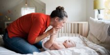 Mother and Baby Play Together on the Bed Motherly