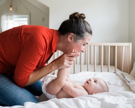 Mother and Baby Play Together on the Bed Motherly