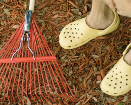 rake and persons feet on mulch