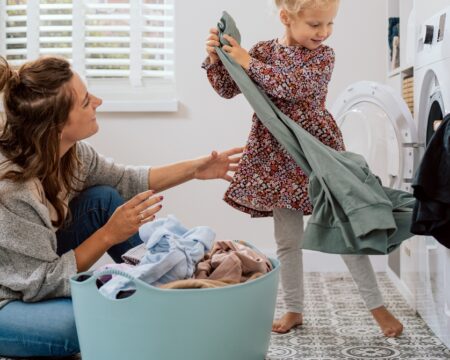 mom and daughter doing laundry Motherly