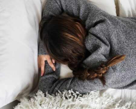 woman laying on her stomach in bed