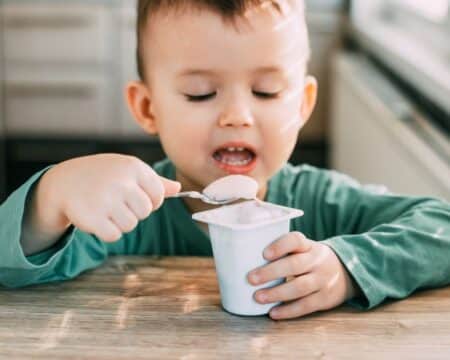 child eating yogurt in the kitchen Motherly