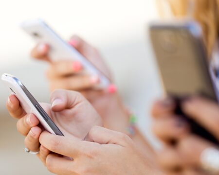 girls hands using cellphones Motherly