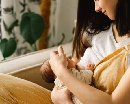 woman breastfeeding baby Motherly