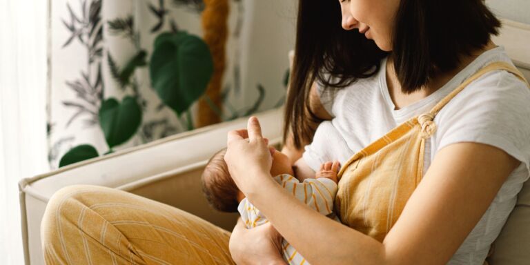 woman breastfeeding baby Motherly
