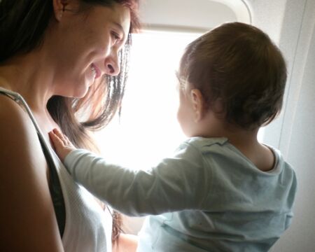 woman on airplane with baby tips for flying with kids