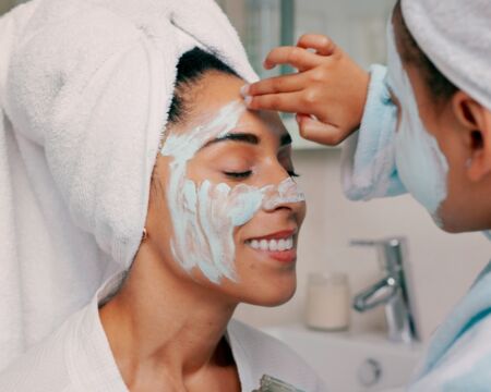 mom and daughter doing masks in bathroom