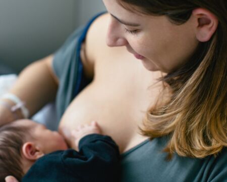 mom breastfeeding newborn baby boy