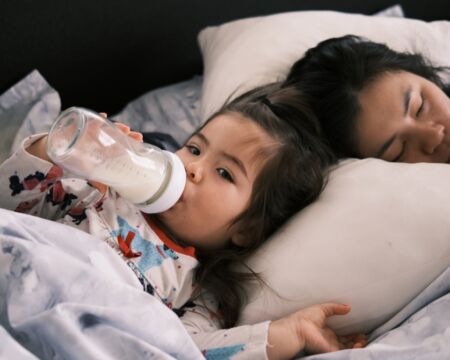 Toddler Girl Drinks Milk Next To Mom In Bed Motherly
