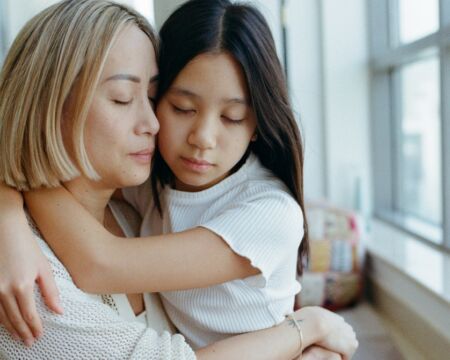 emotional mother and young daughter hugging