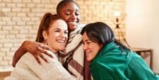 female friends hugging in living room Motherly