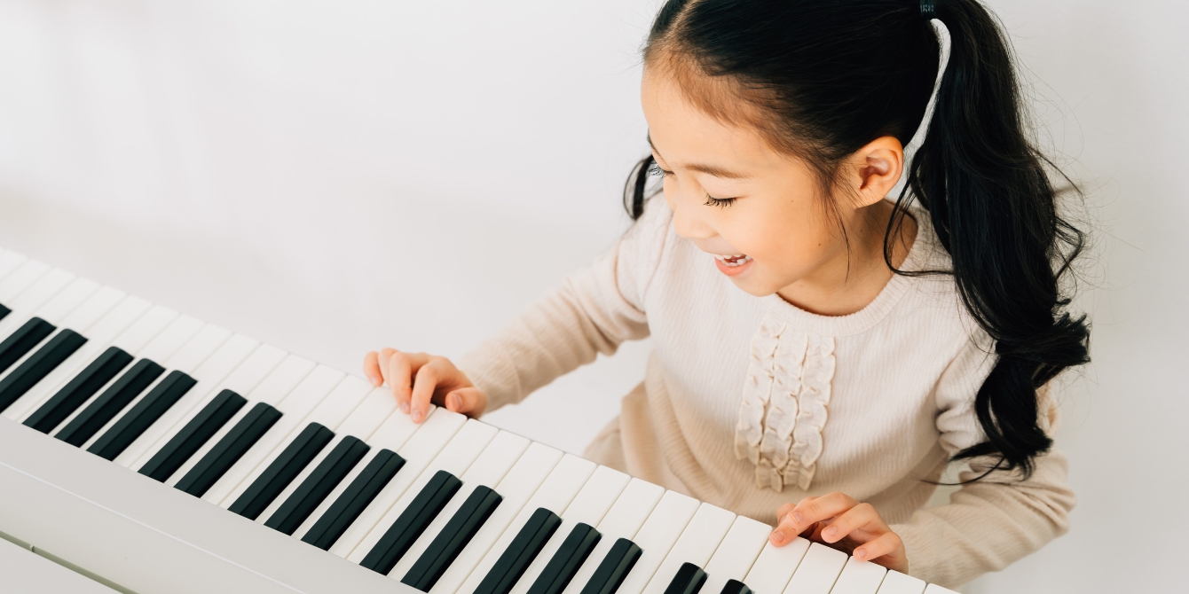 happy girl practicing piano - how to get your kid to practice music