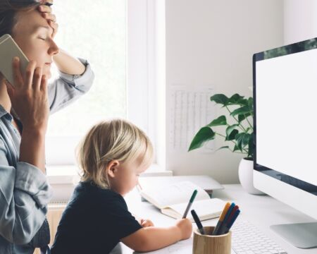 mom on phone working from home with child Motherly