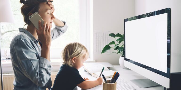 mom on phone working from home with child Motherly