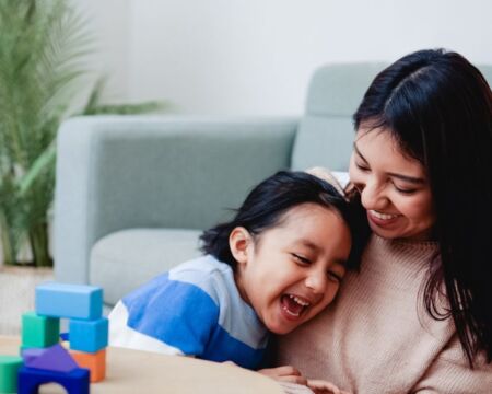 mom playing blocks with child starting montessori at home