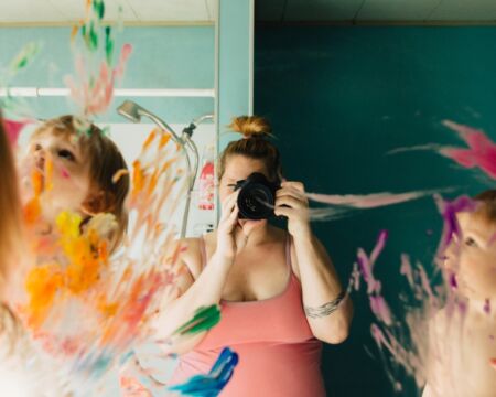 mom taking photo of kids painting on mirror Motherly