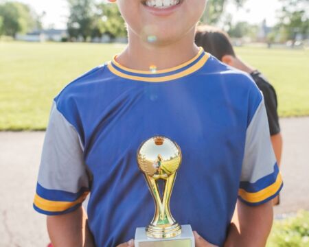 smiling child holding trophy