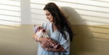 mom holding new baby in hospital Motherly