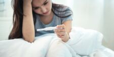 sad woman holding pregnancy test Motherly