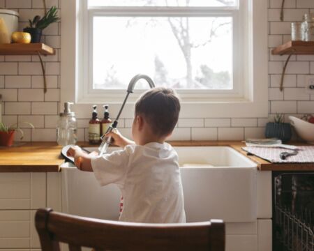 young boy doing dishes in the kitchen Motherly