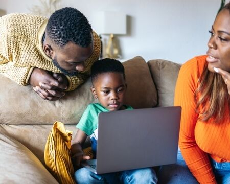 family using laptop at home 720 Motherly
