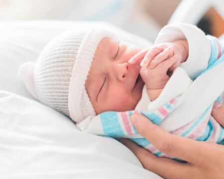 newborn baby in the hospital in mothers hands Motherly