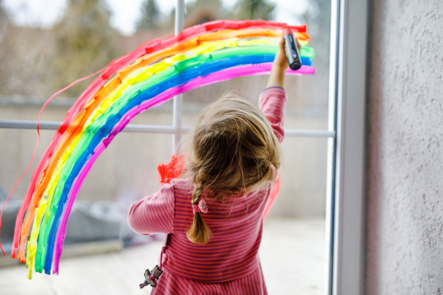 toddler girl rainbow painted on window Motherly