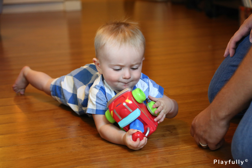 baby holding red plastic car