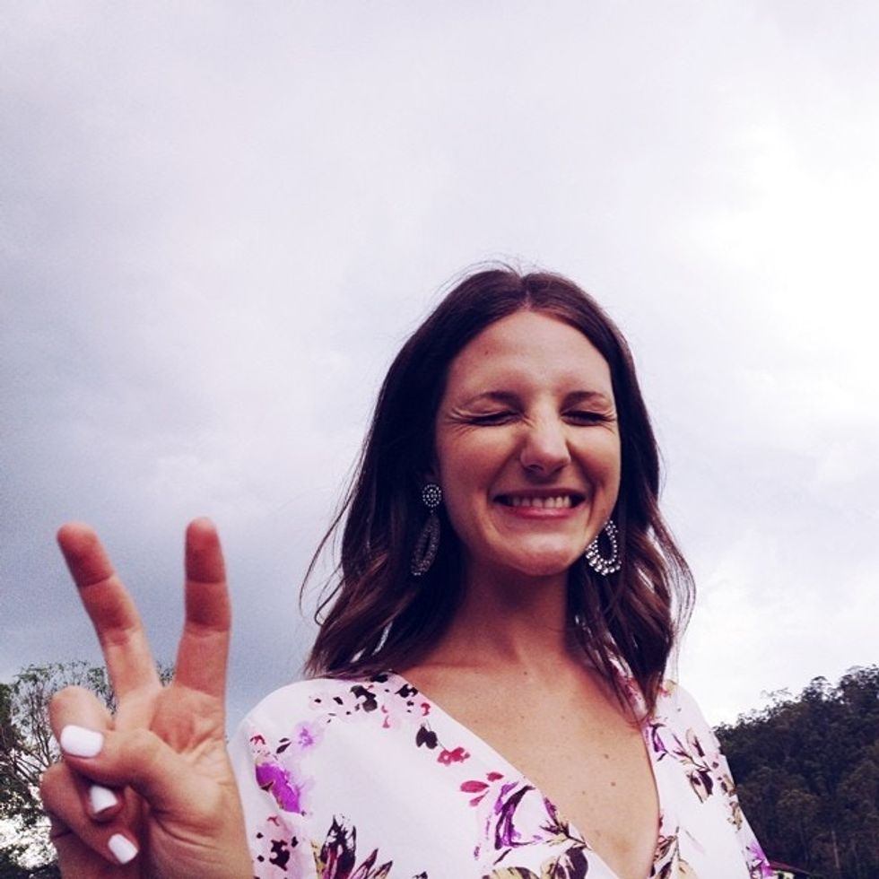 woman smiling while showing peace sign - peaceful mama
