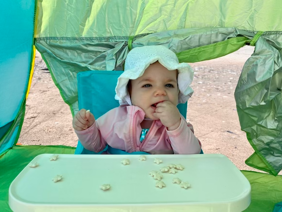 baby-in-portable-high-chair-at-beach