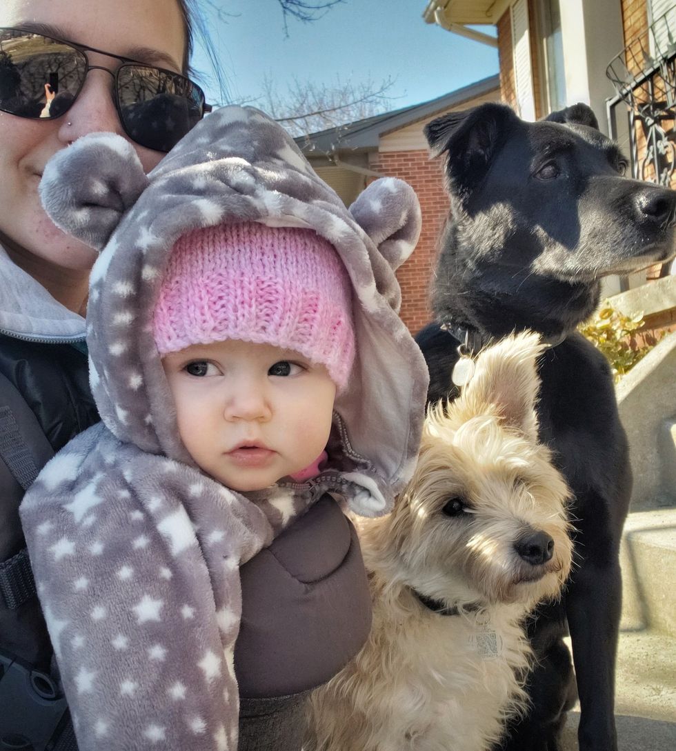 woman outside with baby and dogs